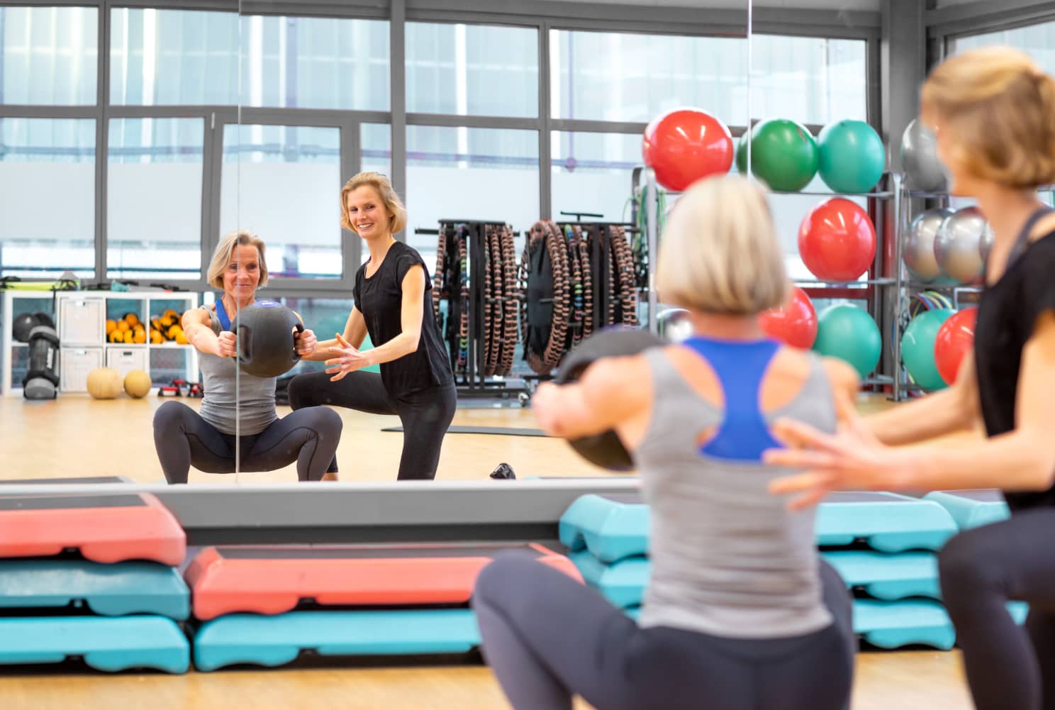 Lisa Stanke aus Hennef trainiert eine Frau in einem hellen Fitnessstudio.